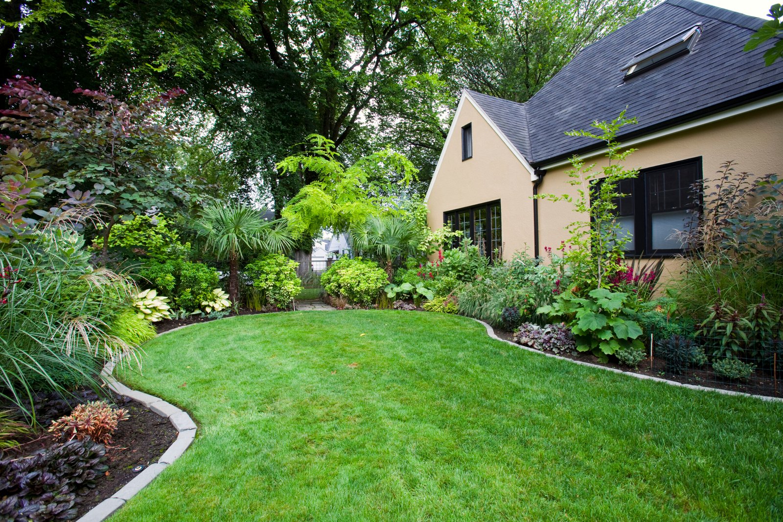 Lush garden with green lawn around a home showing landscape lighting benefits in the San Fernando Valley.